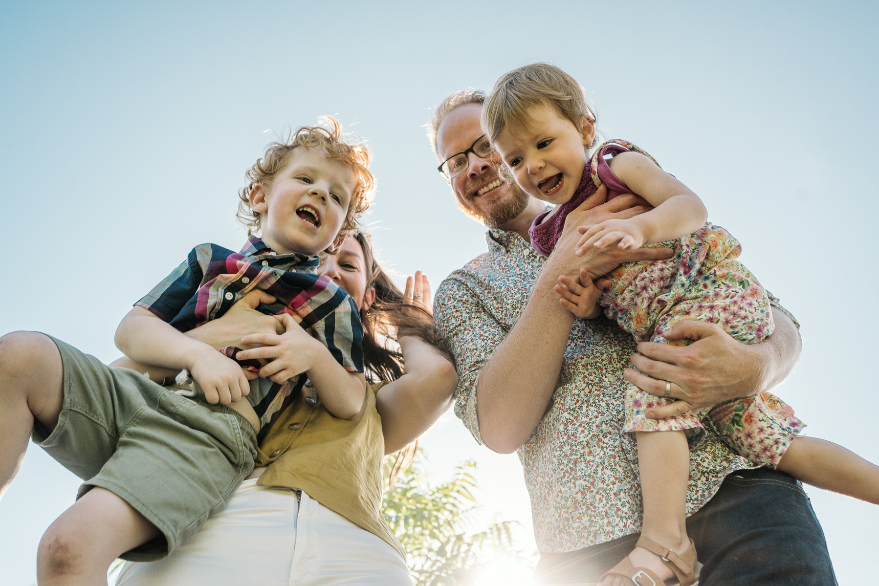 Parents playfully pose with their kids during a family photo session at Fisher Hill Reservoir Park in Chestnut Hill by Brookline family photographer Korri Leigh Photography