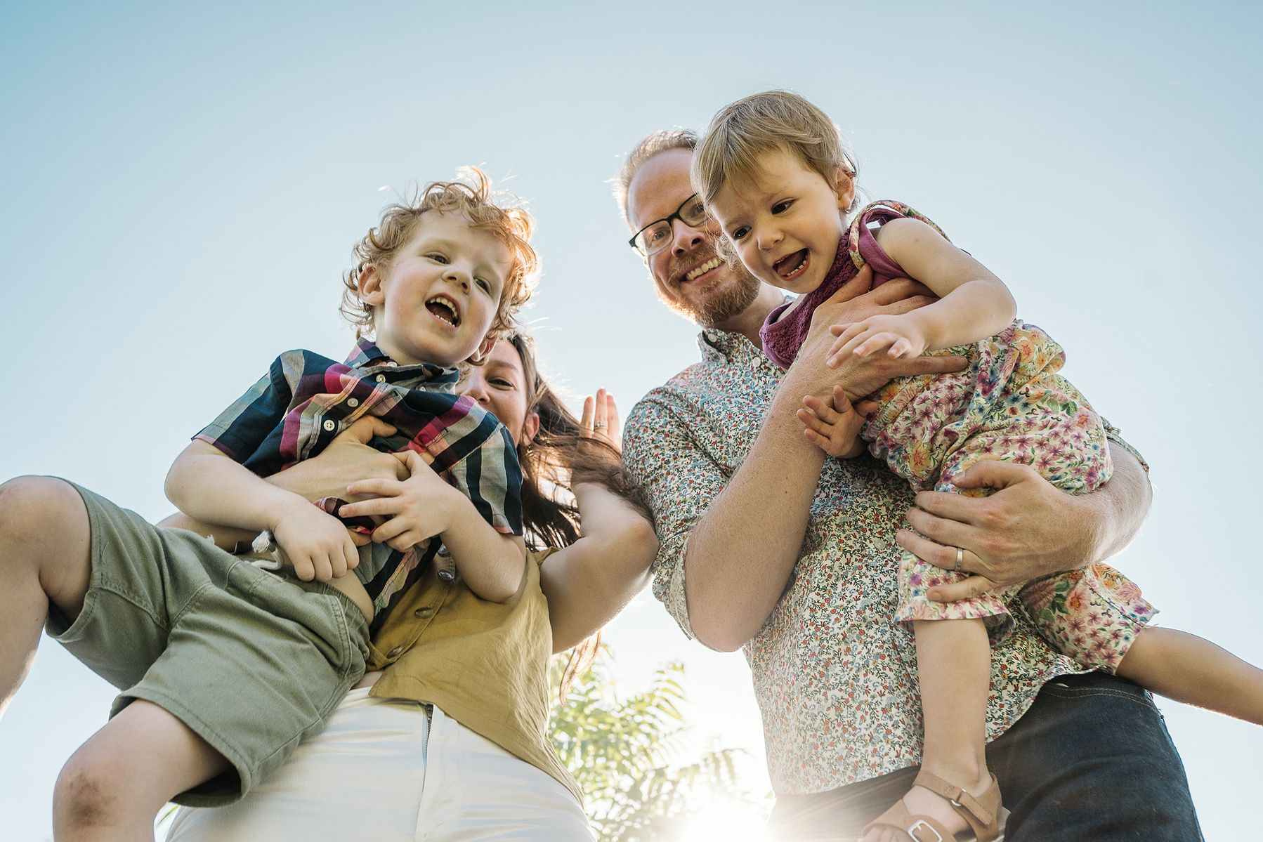 Parents playfully pose with their kids during a family photo session at Fisher Hill Reservoir Park in Chestnut Hill by Brookline family photographer Korri Leigh Photography