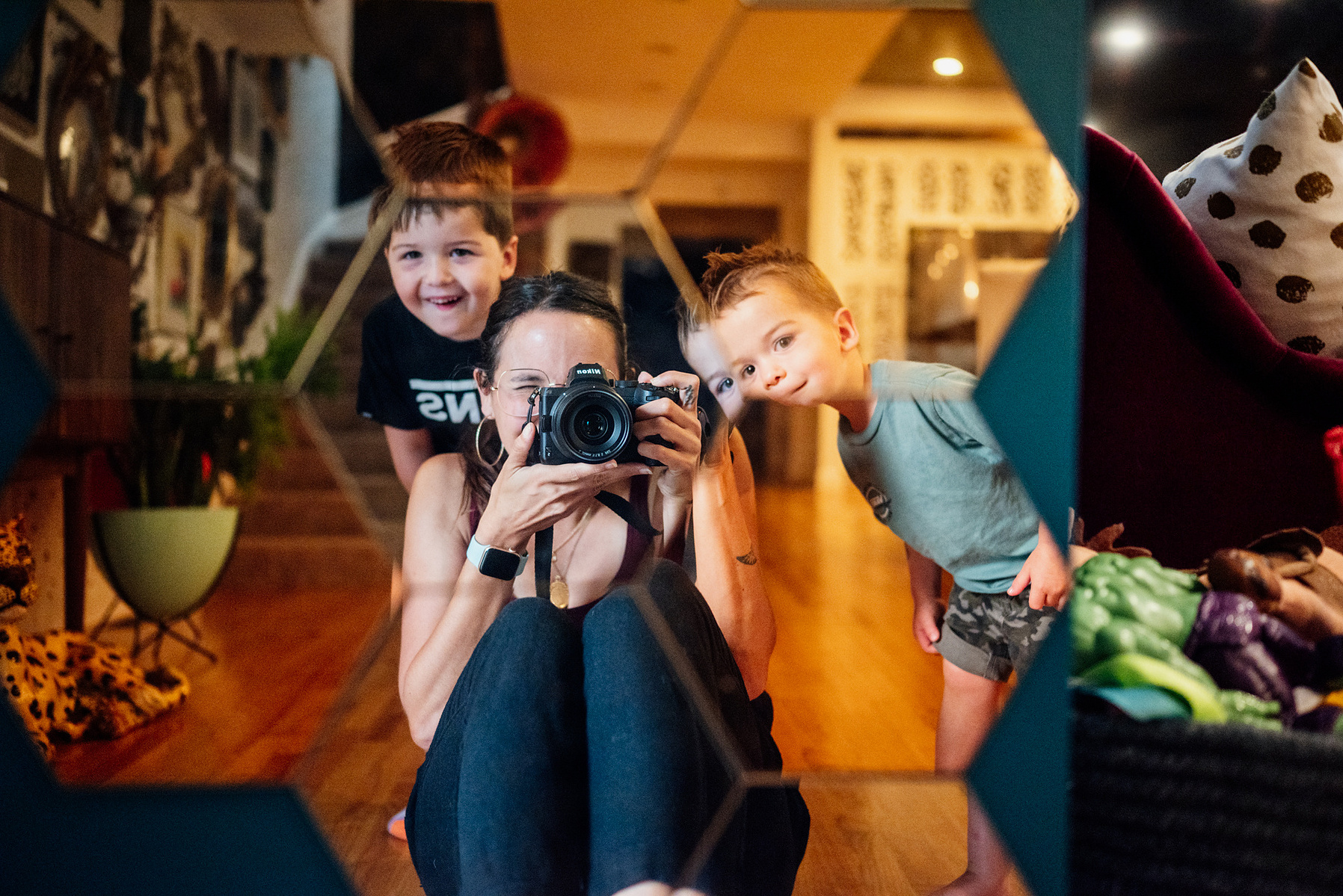 West Roxbury family photographer Korri Leigh Crowley takes a photo of herself and two young boys in the mirror during an in home family photography session 