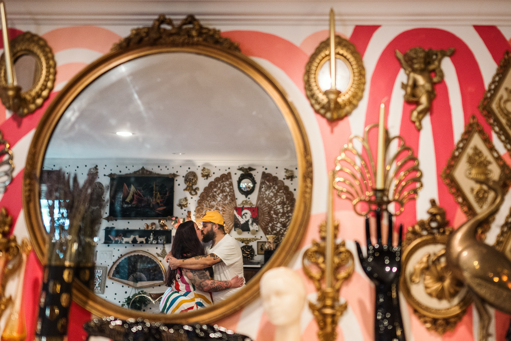 A Mom and Dad hug while reflected in a mirror in their maximalist designed Salem Massachusetts home