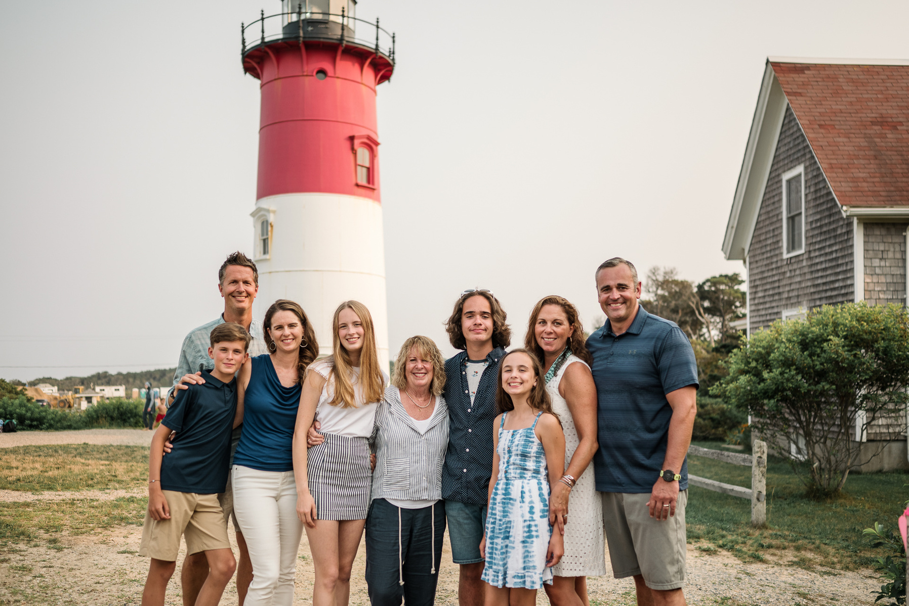 An extended family poses in front of the Nauset Lighthouse in Eastham on Cape Cod in Massachusetts