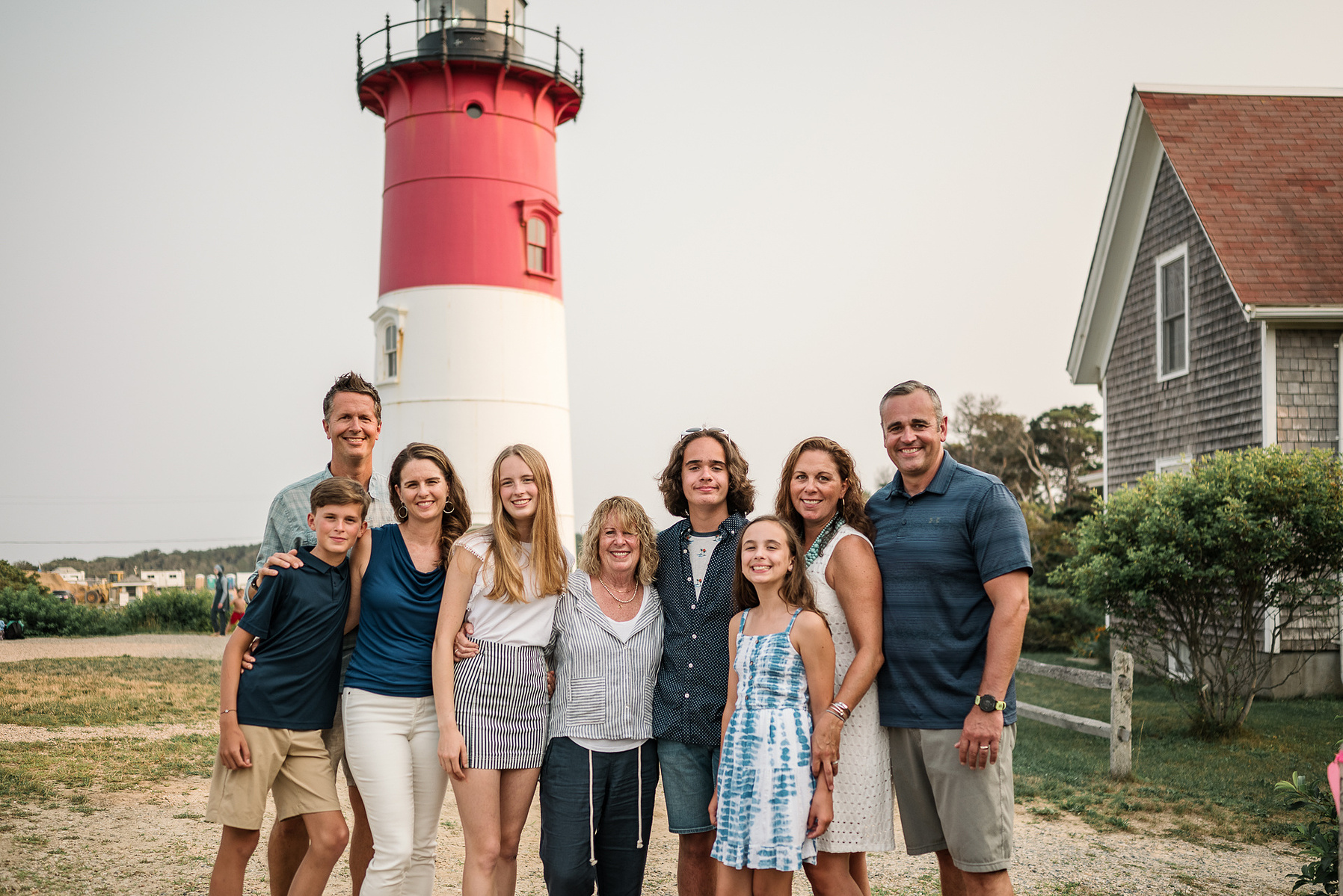An extended family poses in front of the Nauset Lighthouse in Eastham on Cape Cod in Massachusetts