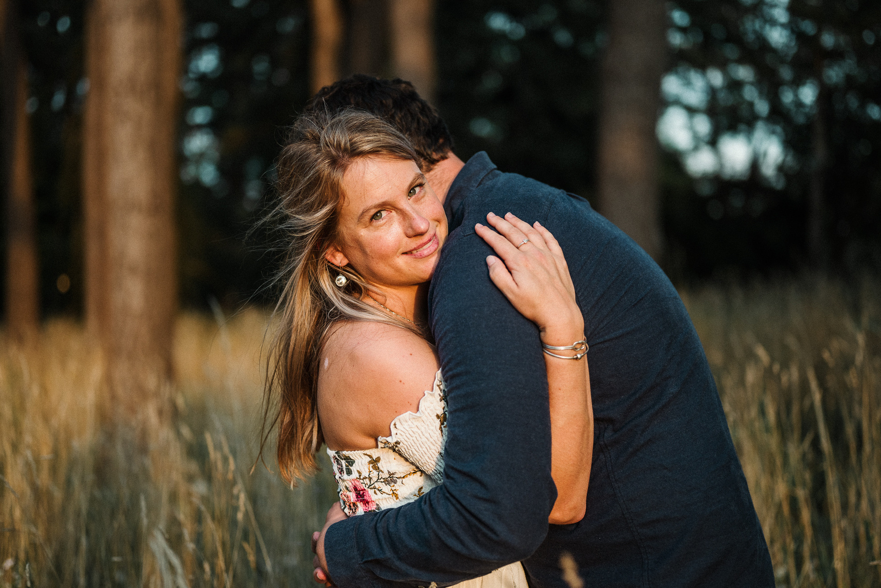 a woman hugs her partner and looks at the photographer korri leigh crowley