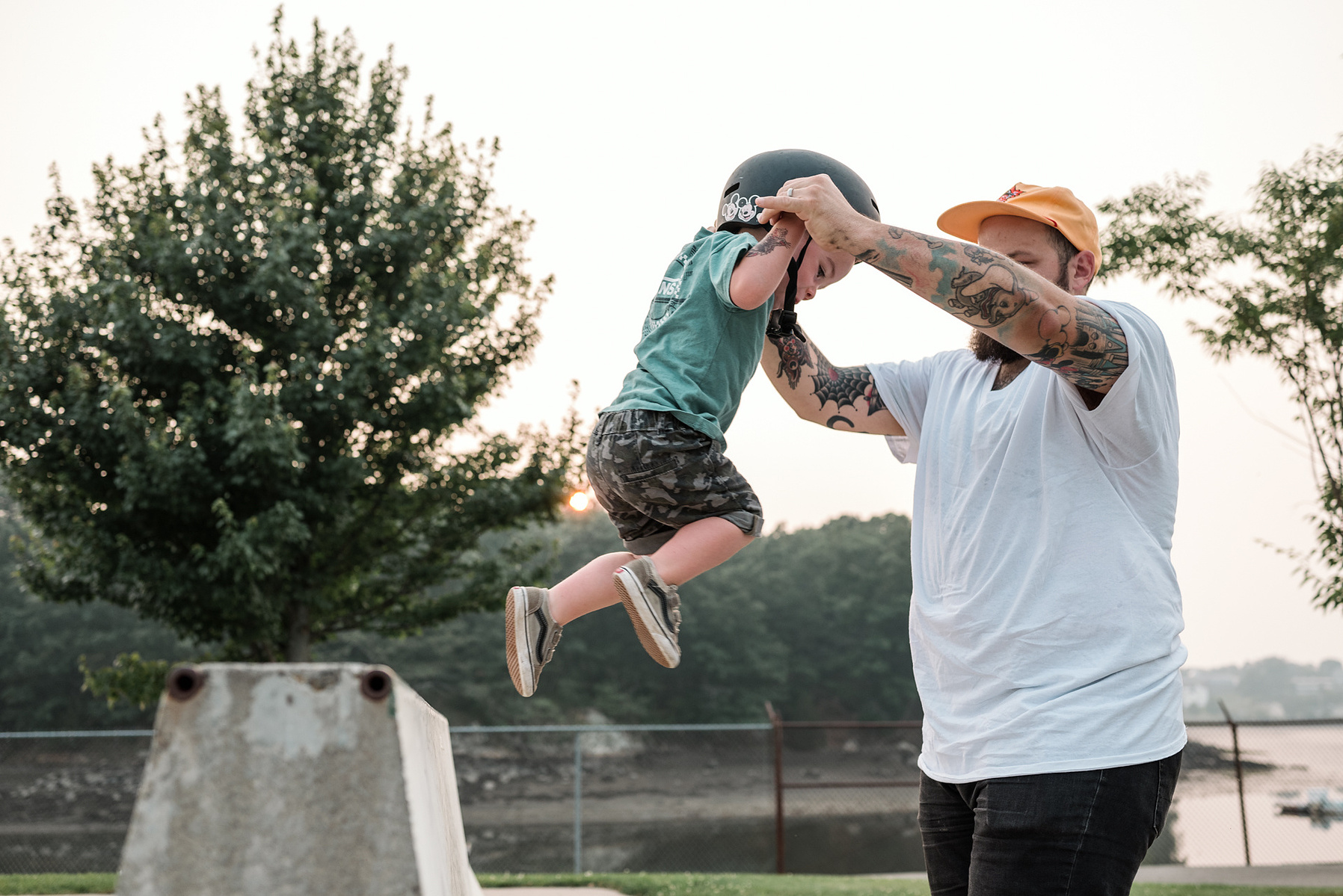 A young boy plays with his tattooed dad during a family photo shoot at Innocenti skatepark in Beverly MA