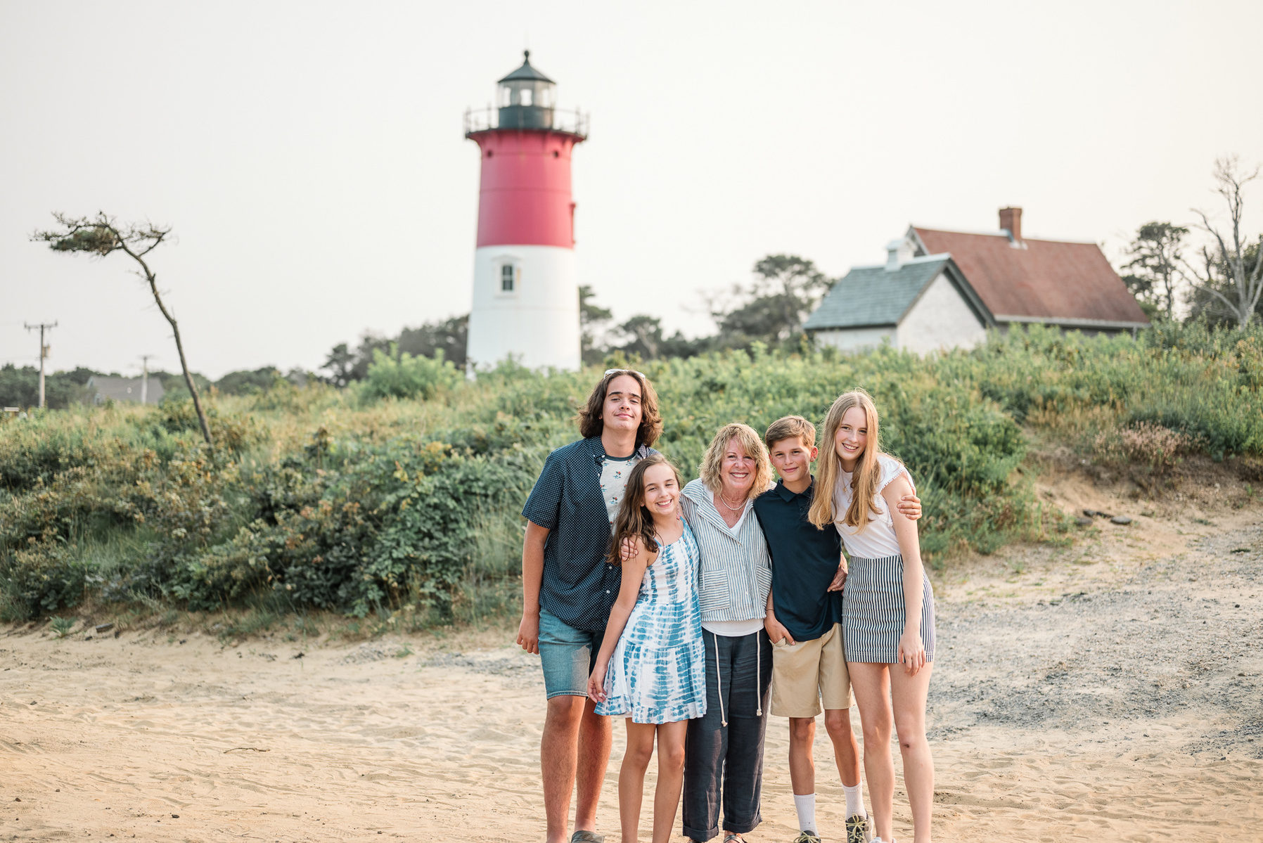 A grandmother poses with her grandchildren during an extended family photo session on Cape Cod Massachusetts