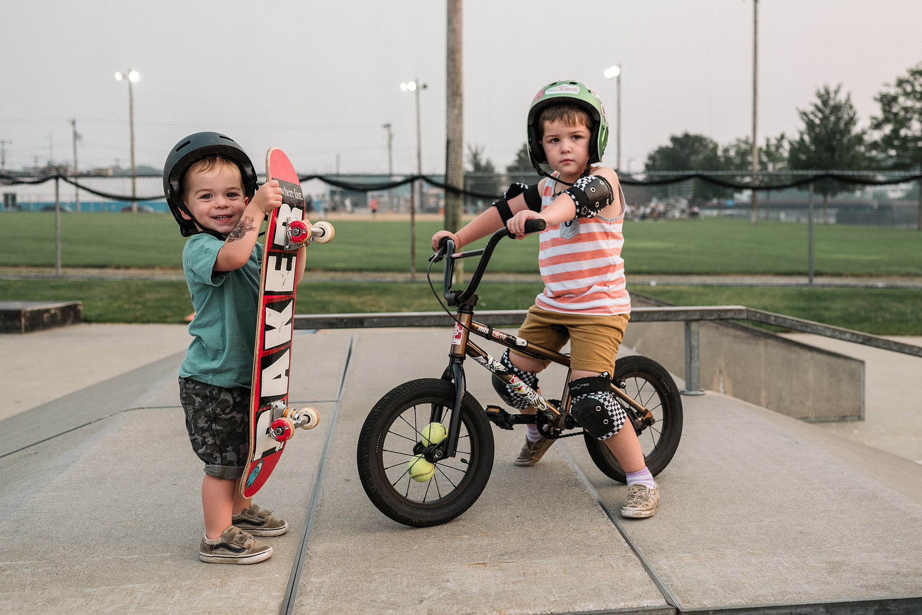 Two young boys pose with their skateboard and bmx bike during a family photo shoot at Innocenti skatepark in Beverly MA
