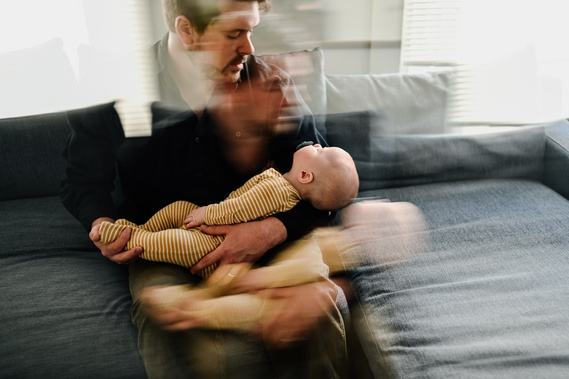 A double exposure of a father holding his baby soon in his arms during a boston family photoshoot 