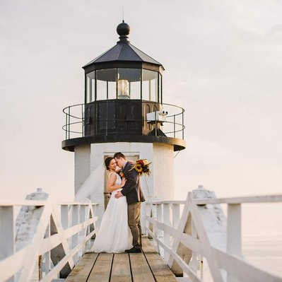 A couple embraces on the Maine coast during their Marshall Point Lighthouse elopement