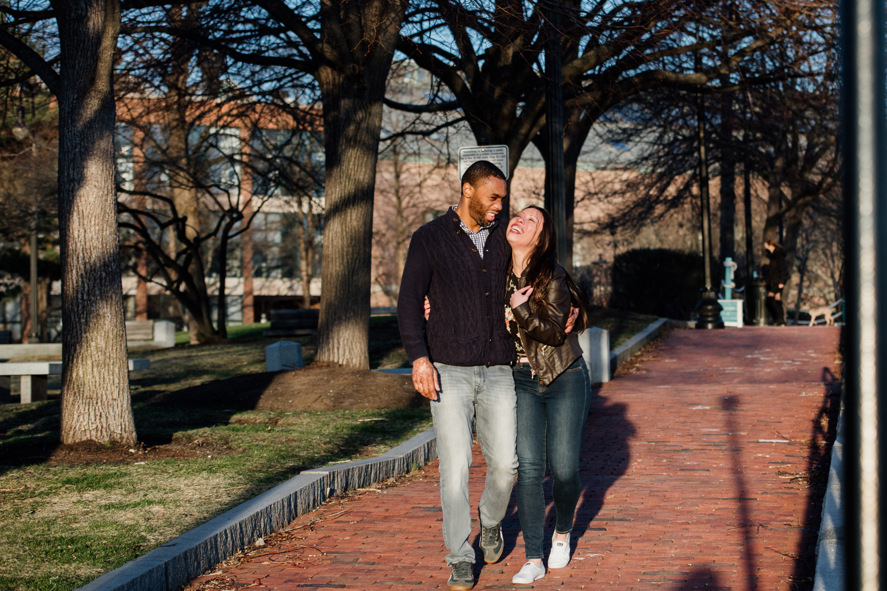 A couple walk, hug, and laugh after their Boston proposal