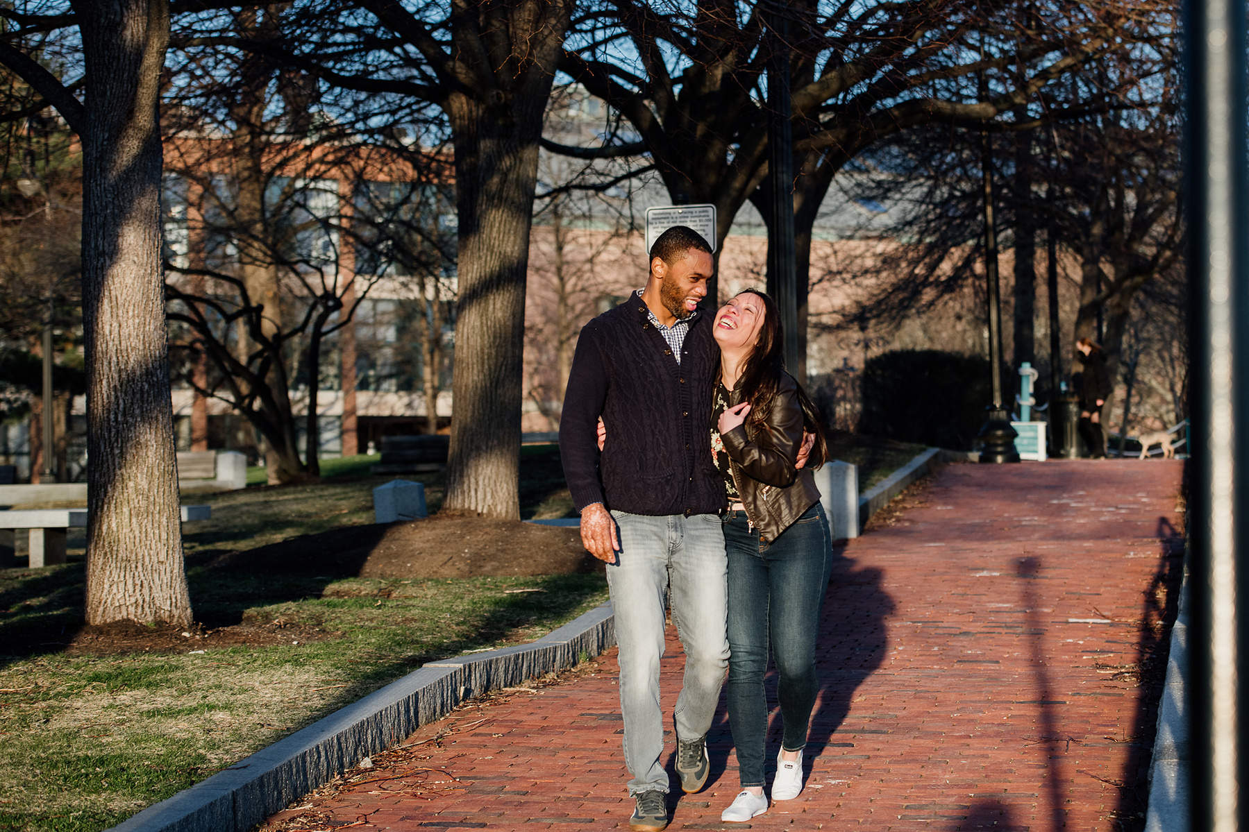 A couple walk, hug, and laugh after their Boston proposal