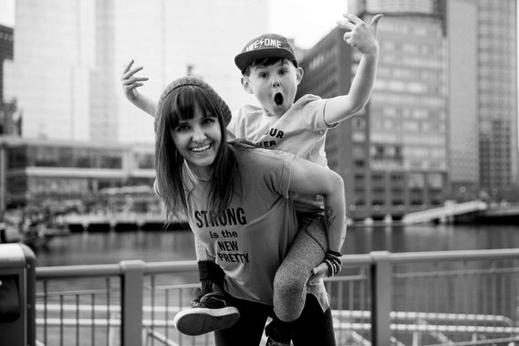 Boston photographer Korri Leigh Crowley gives her son a piggyback while they both smile and make faces 