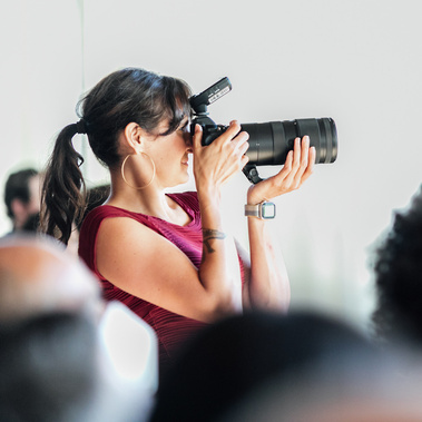 Boston elopement photographer Korri Leigh Crowley takes a photo at a wedding with a large Nikon camera and zoom lens