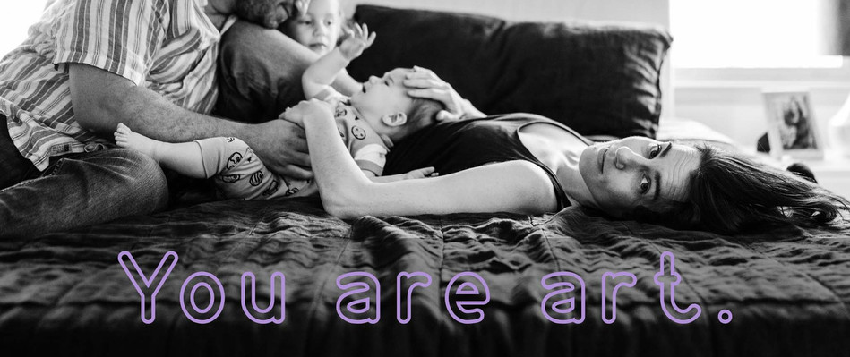 A mother looks at the camera while laying on a bed with her family
