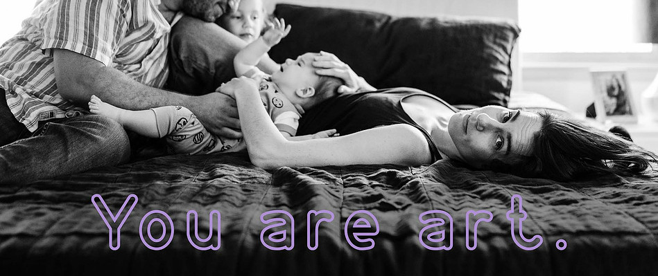 A mother looks at the camera while laying on a bed with her family