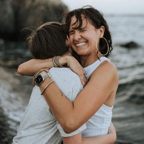 Boston family photographer Korri Leigh crowley giver her son a big hug on the beach while closing her eyes and smiling wide