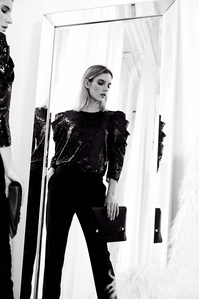 blonde female model chloe holmes standing in front of mirror dressed in black sequin holding clutch purse, photograph by William Gormley