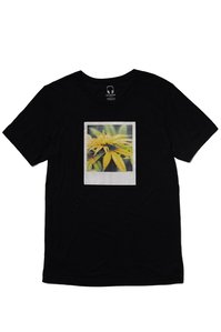 black t shirt laying with a graphic of marijuana leaves plant on front of it and is laying flat on white background surface