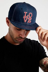 blue denim baseball cap hat with graphic of the word love stitched on the front being worn on a male model wearing a black t shirt
