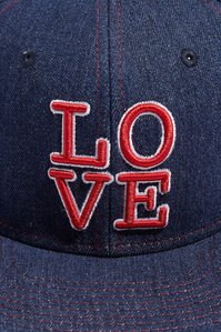 blue denim baseball cap hat with graphic of the word love stitched on the front