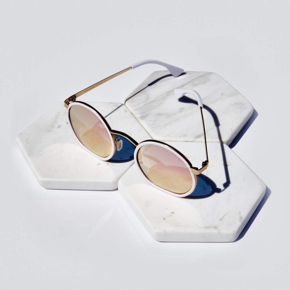 round sunglasses product pink and gold  mirrored lenses on white tiles background
