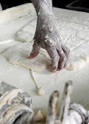 The hands of Café Du Monde employee, Gerald Taylor covered in flour as they prepare the beignets for the next step. This photo was taken at the Café du Monde location in New Orleans, Louisiana on Tuesday, Aug. 8,2017 (Katherine C. Gilyard/NABJ Monitor)