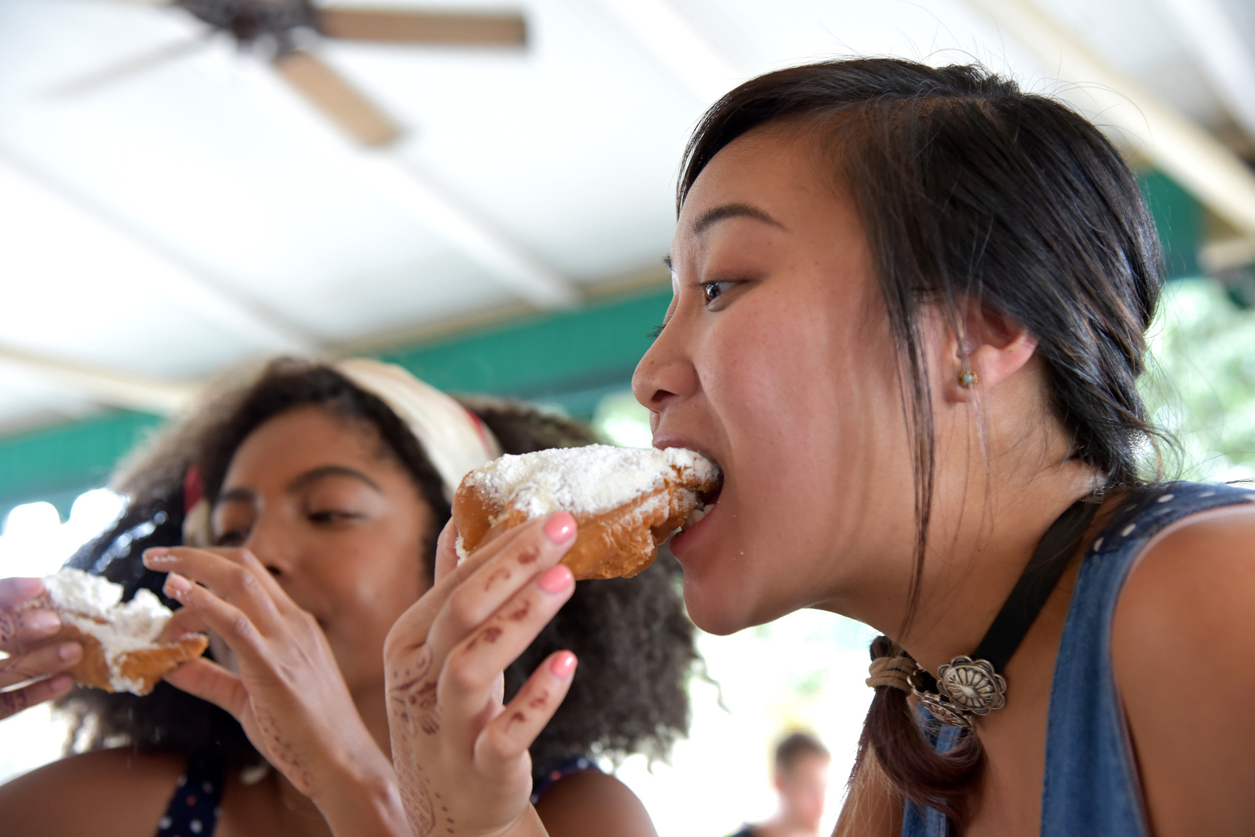 Kym Allen (Left) and Aimee Cruz(Right) enjoying beignets and coffee at the Café Du Monde in New Orleans, Louisiana on Tuesday, Aug. 8,2017 (Katherine C. Gilyard/NABJ Monitor)
