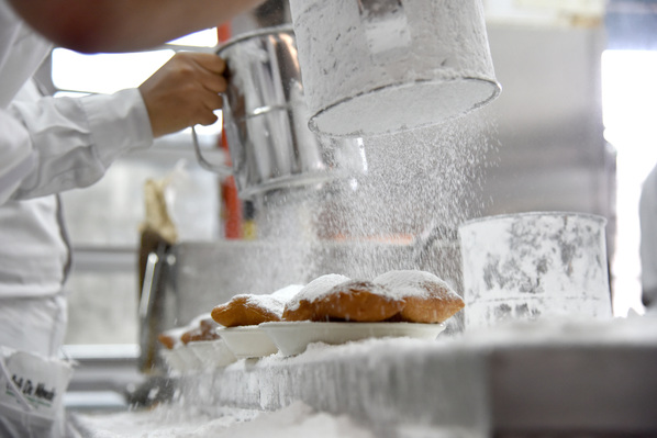 Café Du Monde employee, Jovy Jones sifting powdered sugar onto beignets right before their served in New Orleans, Louisiana Tuesday, Aug. 8, 2107 (Katherine C. Gilyard/ NABJ Monitor)