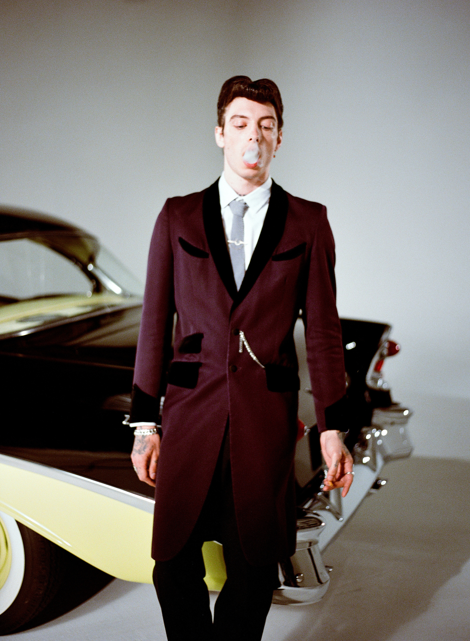 Analog film photo of a model by a vintage car.