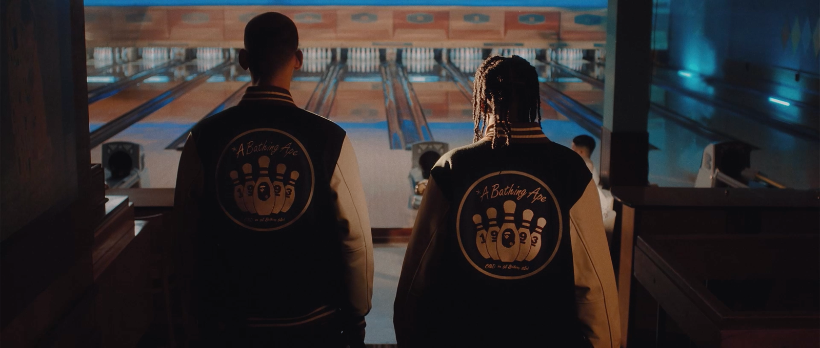Silhouette of two competitors wearing the product and entering the bowling alley.