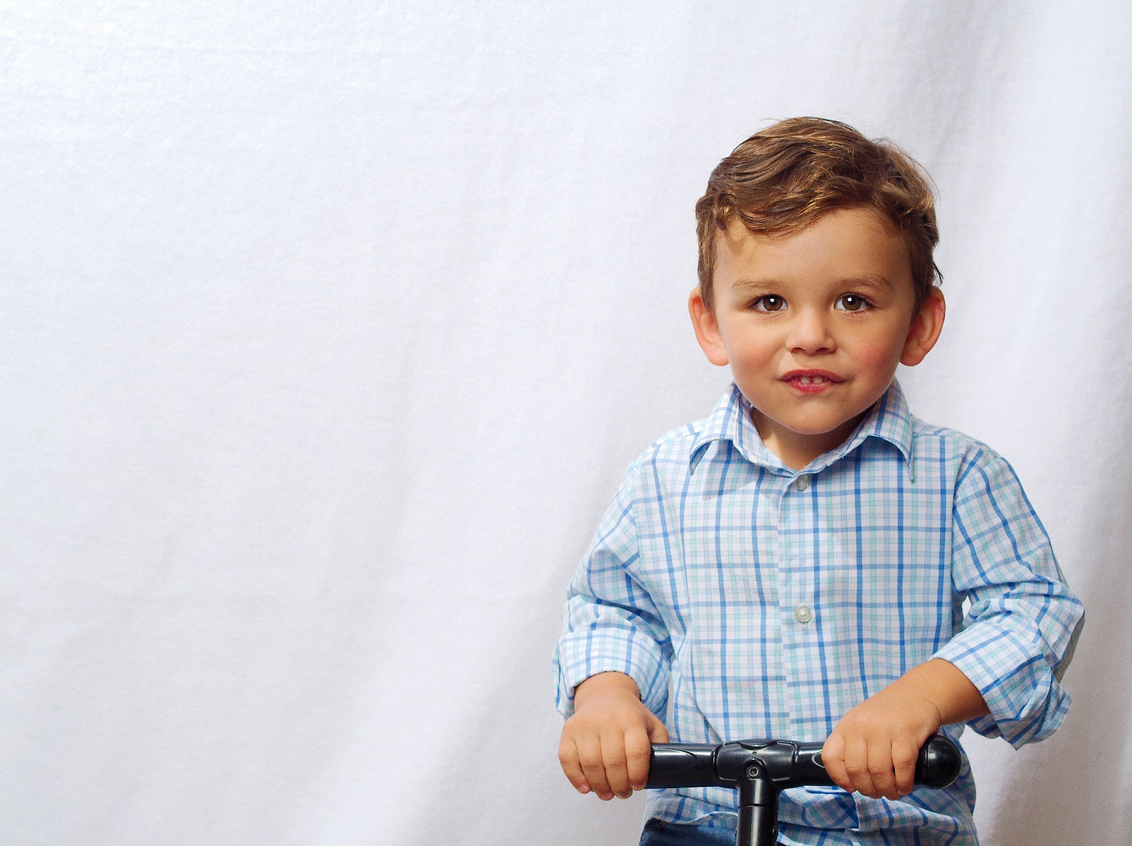 Image Description:  "A tuff toddler on his riding toy posing for a high key portrait."