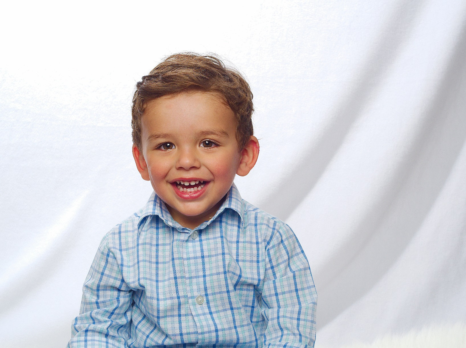 Photo description: "A smiling toddler with a ball during a high key photo session."