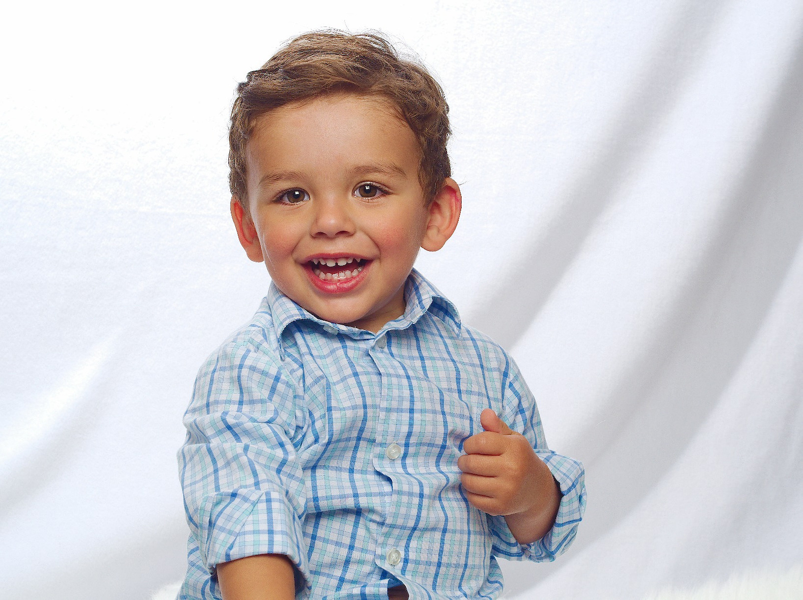 Photo description: "A smiling toddler with a ball during a high key photo session."