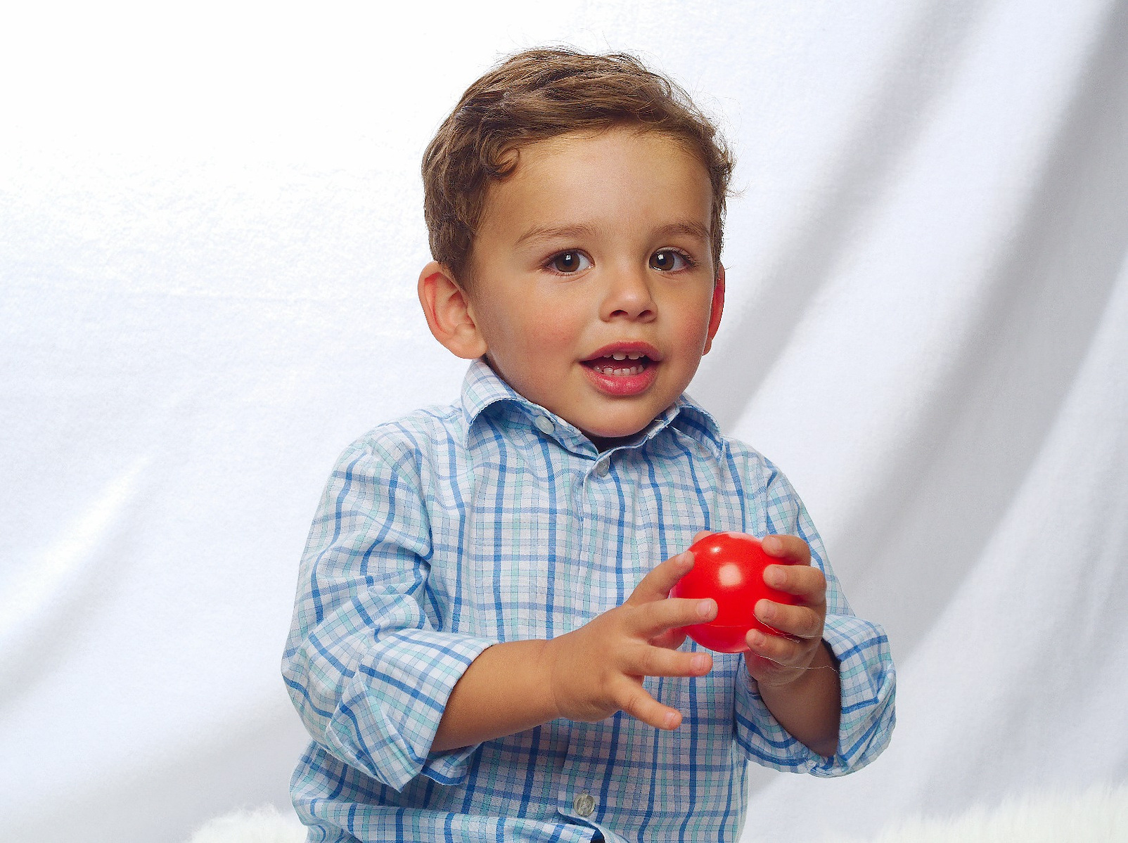 Photo description: "A toddler with a ball during a high key photo session."