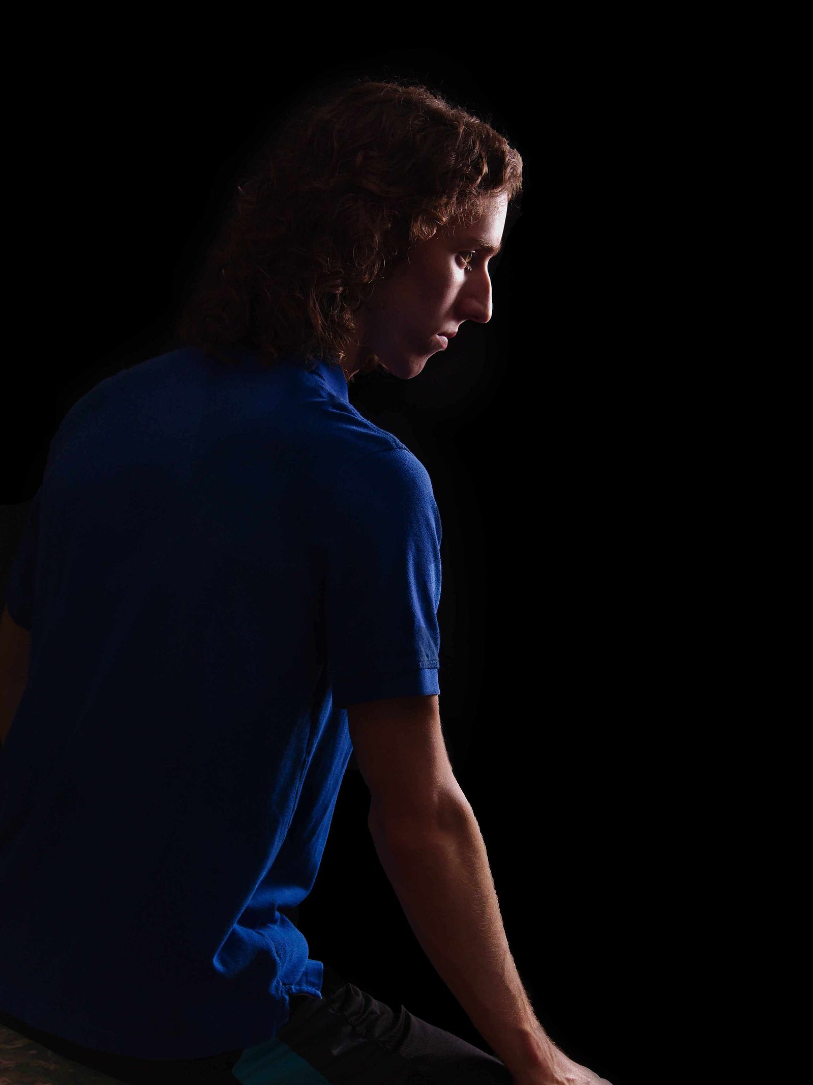 Image Description: "Uncropped Image of Young Man on a black image.  Rembrandt Lighting is used."