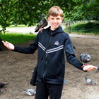 A young man feeding the birds in Hyde park