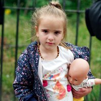 Young girl In Hyde park waiting for her family as they feed the birds