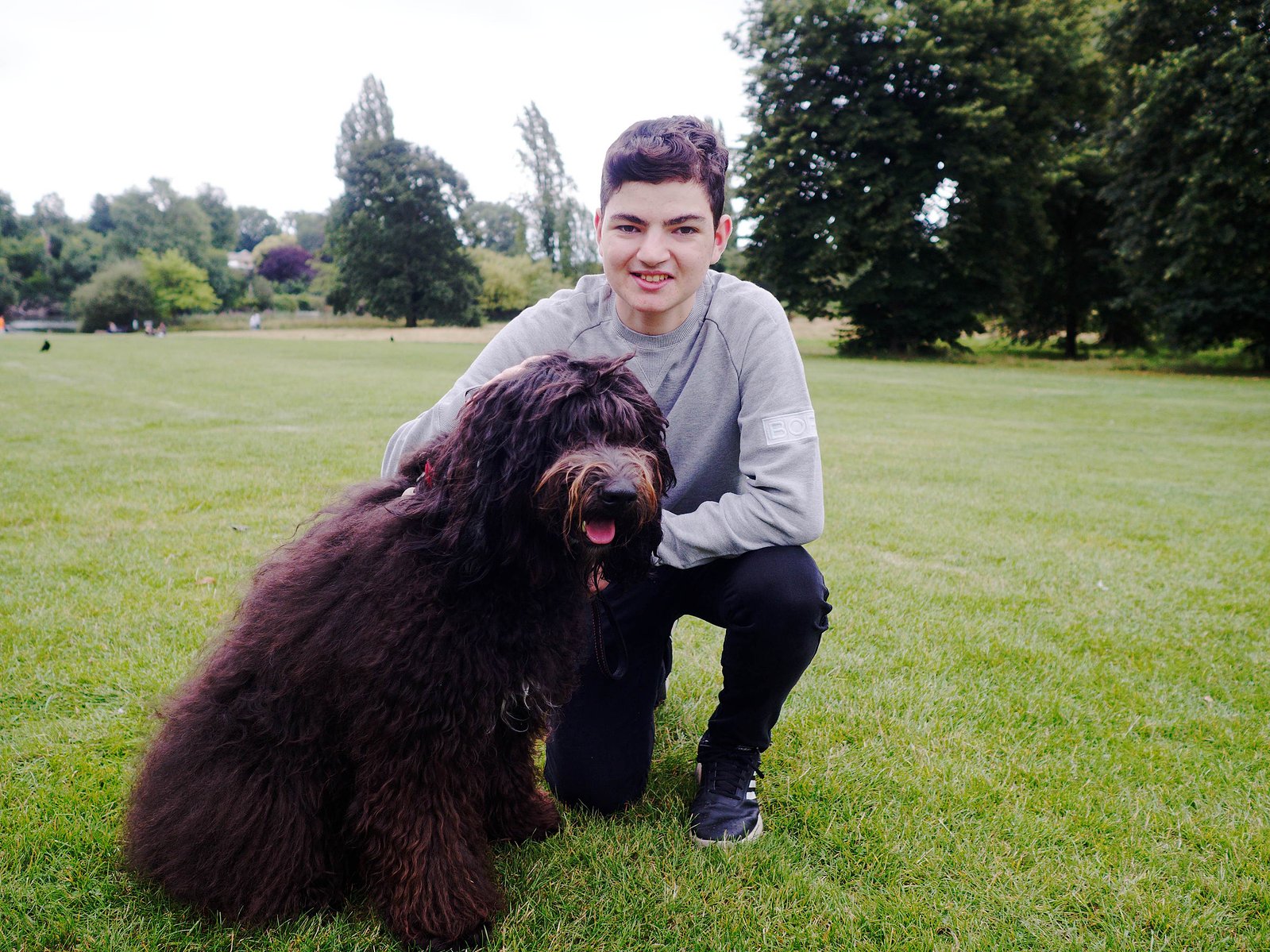 This is a photograph of a young man and his dog in Hyde Park