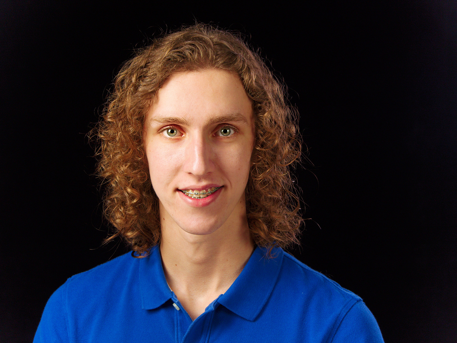 Image Description: "Headshot of a young man on a black background using Rembrandt lighting."