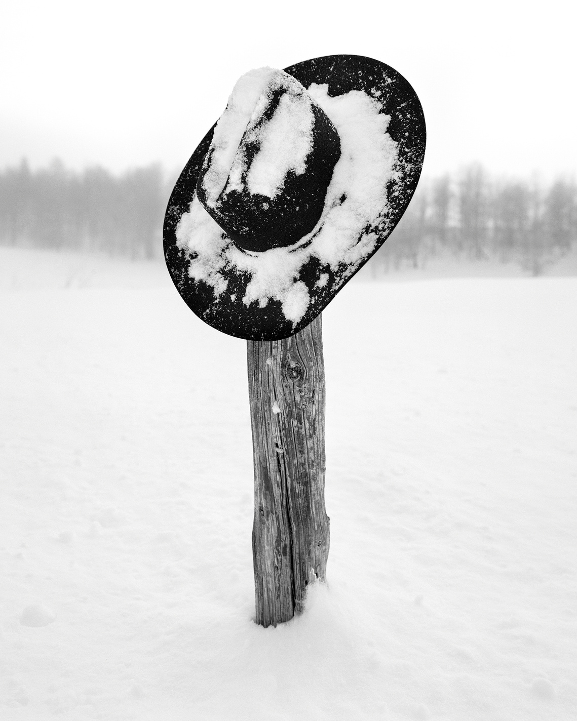 Fine art photograph of cowboy hat on fence post during the winter in the Grand Teton National Park, Wyoming. Western artwork of cowboy hat in the snow. Western Winter artwork.