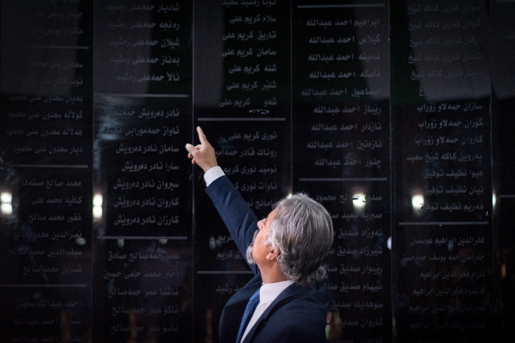 Halabja, KRI. Inside the Halabja Monument and Peace Museum, Omed Hama Ali Rashid (48), is pointing at the names of the family members he lost on the 16th of March 1988 as a result of the chemical attack on the city of Halabja by Saddam Hussein's forces.