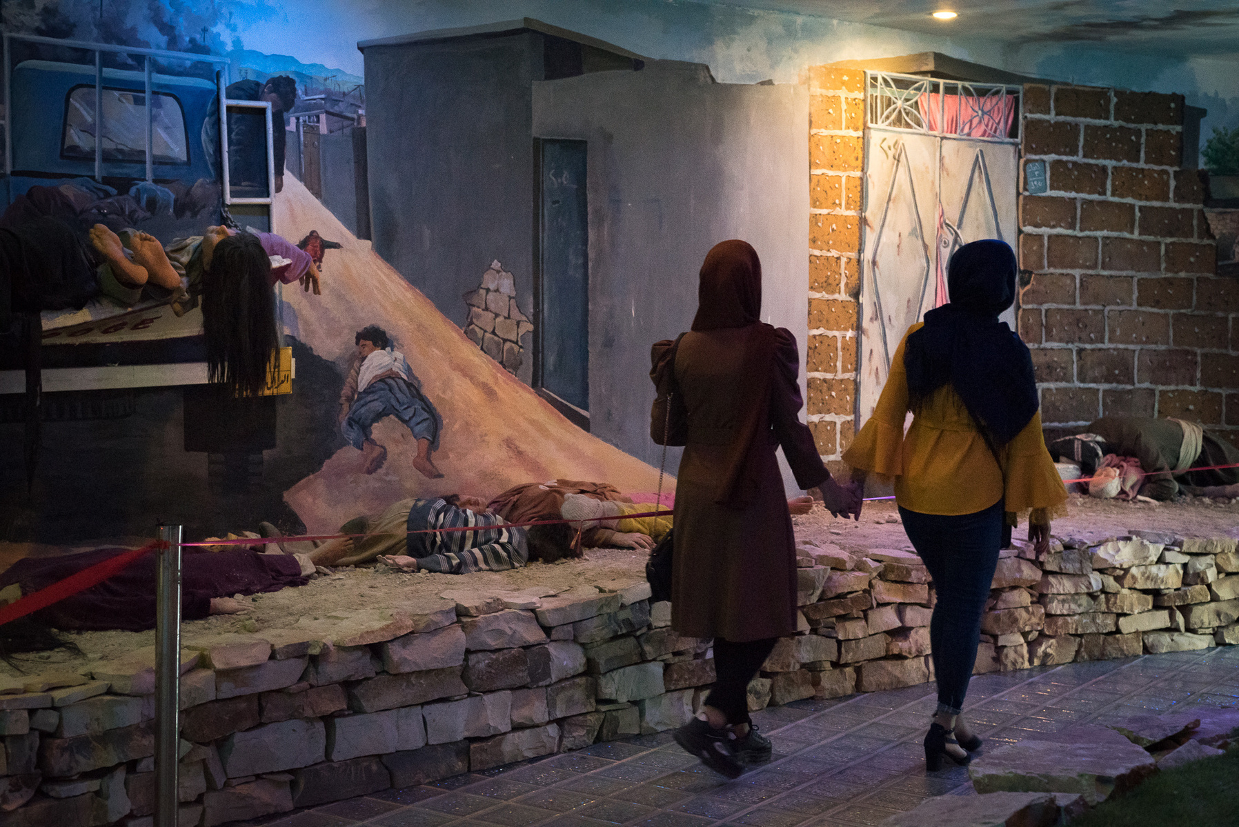 Halabja, KRI. Two girls are visiting the second room of the Halabja Monument and Peace Museum, that displays the “Merga Sat” (“moment of death” in Kurdish). Here, the scenes, photographed by the first reporters who entered the city a few days after the ch