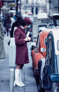 A fashionably female uniformed parking attendant issued a fine for a long-parked car in the centre of Paris.