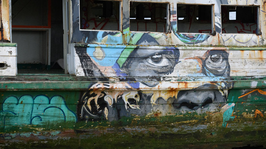 Along the road to the shipyard just outside Setúbal (Portugal), there is a site where I’ve come across various derelict boats over the past 25 years. A graffiti artist has adorned this decaying tour boat with a colourful piece of street art.