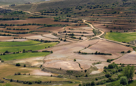 Arid landscape near Escucha in Teruel, Spain, showing rolling hills, dry terrain, and sparse vegetation under a wide, open sky.
