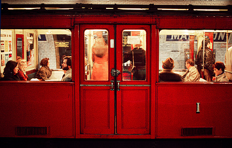 Red-coloured metro with passengers in the underground from Paris.