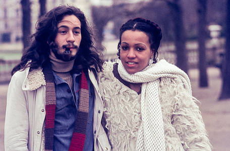 Hippie-style dressed couple posing on the street for the photographer in Paris in 1974.
