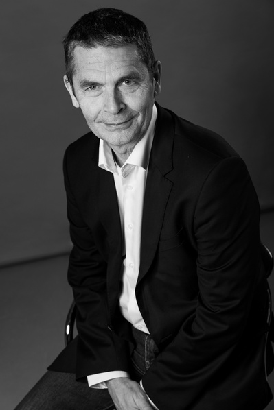 Portrait noir et blanc en buste de Xavier Goube fait en studio sur fond gris à Revel.