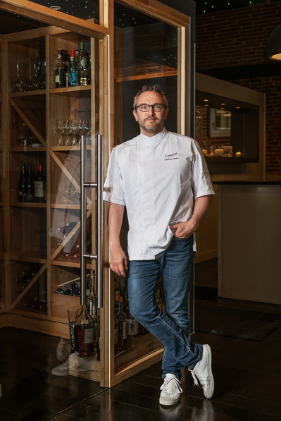 Portrait en situation de Jeremy Morin, chef du restaurant l'Aparté à Toulouse. Il est photographié en pied.