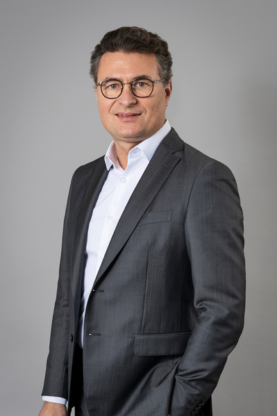 Portrait en couleur cadré en buste d'un responsable de l'entreprise Deloitte à Balma fait en studio sur fond gris.