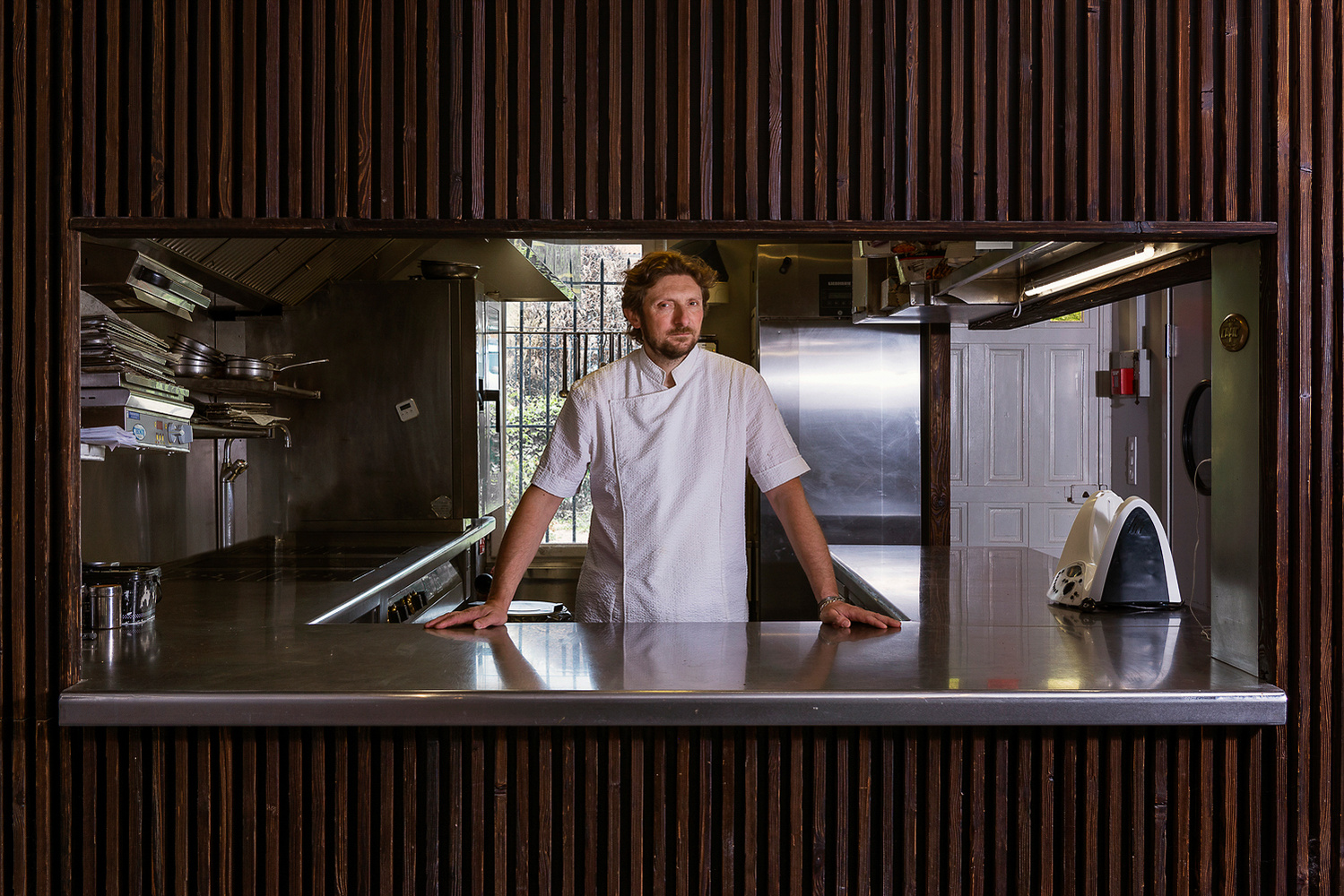 Portrait de Sylvain Joffre dans sa cuisine, chef étoile du restaurant gastronomique En Pleine Nature.
